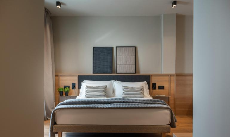 Camera moderna con letto matrimoniale e decorazioni minimaliste.