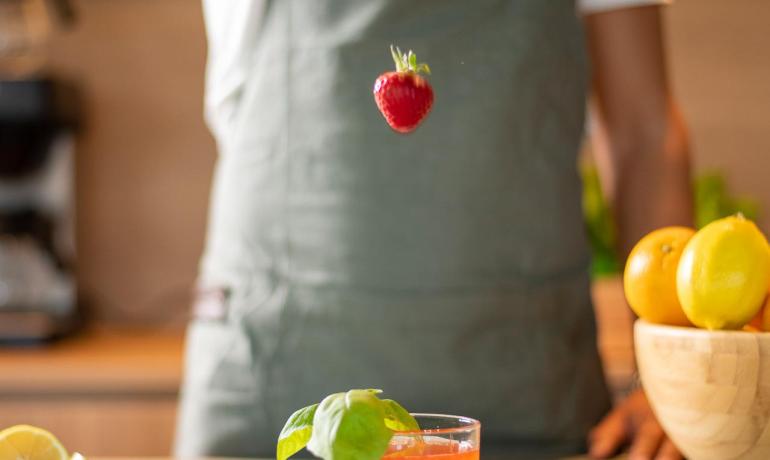 Barman che aggiunge una fragola a un cocktail in cucina.