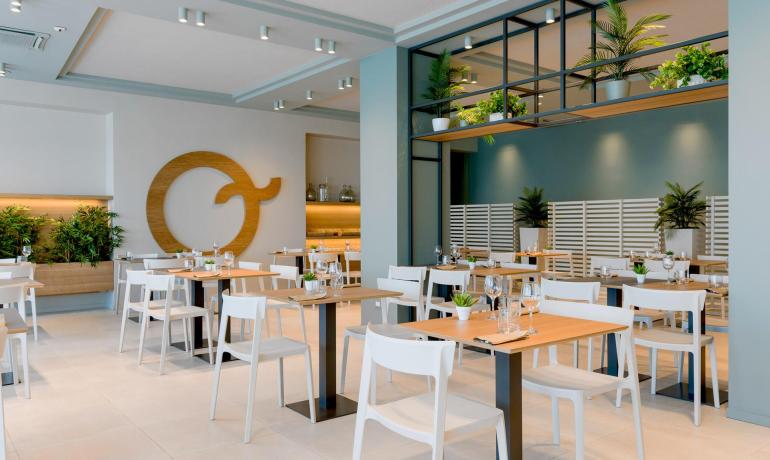 Ristorante moderno con arredamento minimalista e piante verdi.